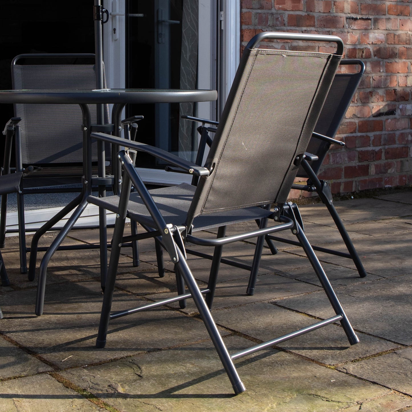 Samuel Alexander Outdoor 4 Seater Round Glass Top Table and Chairs Patio Set with Parasol in Black