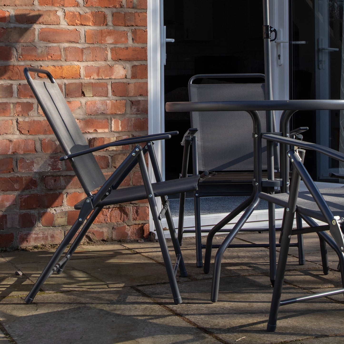 Samuel Alexander Outdoor 4 Seater Round Glass Top Table and Chairs Patio Set with Parasol in Black