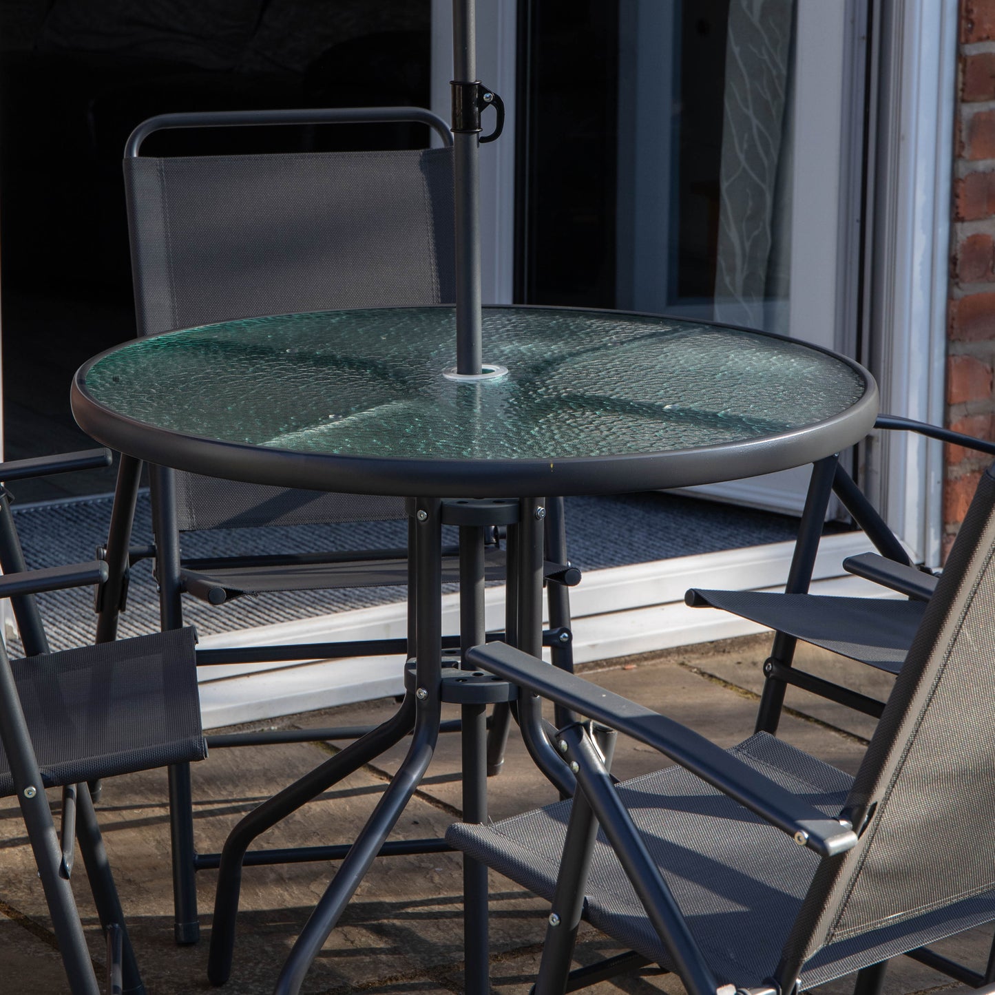 Samuel Alexander Outdoor 4 Seater Round Glass Top Table and Chairs Patio Set with Parasol in Black